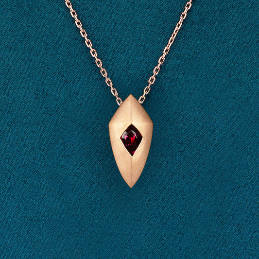 Luxury Freccia Scarlatta pendant handcrafted in 18K satin-finished rose ethical gold, featuring a striking red garnet—an arrow of passion, energy, and direction by Riccardo Contini