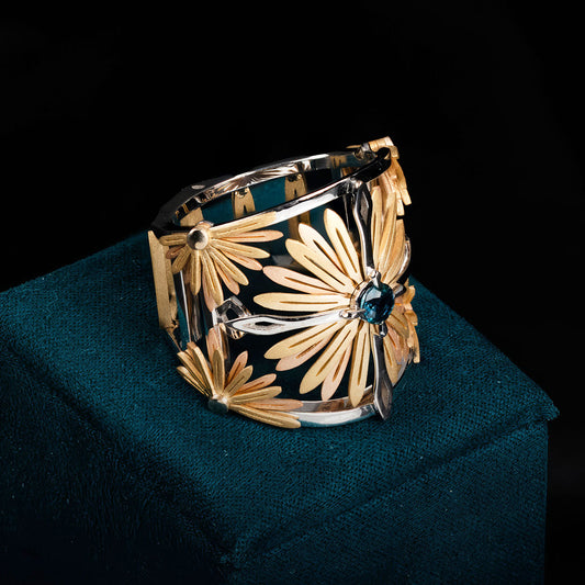 Luxury Sospiro di Echinacea ring handcrafted in 18K ethical gold, adorned with a sapphire—an elegant tribute to the healing strength of the Echinacea flower. Designed by Riccardo Contini