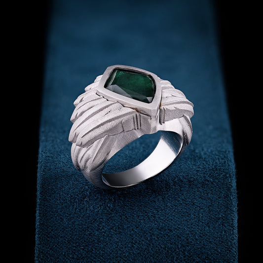 This ring wraps the hand in sculpted lightness, its emerald core held by a crown of carved wings.&nbsp;A symbol of ascent, identity, and the silent strength of becoming.