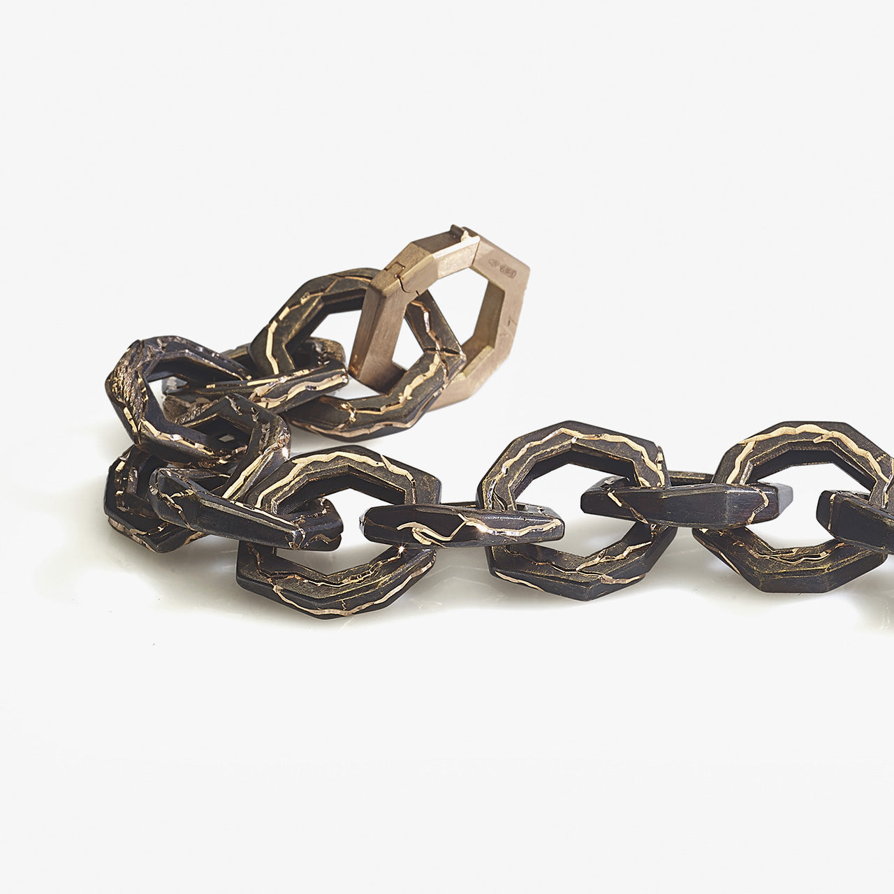 Luxury Braci bracelet handcrafted in 18K rose ethical gold with burned engravings, a symbol of enduring flame and artistic resilience by Riccardo Contini