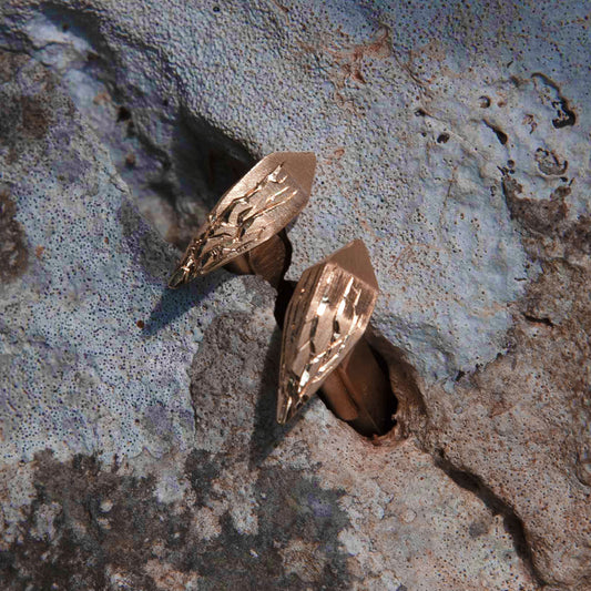 Luxury Infranti Distanti cufflinks handcrafted in 18K rose ethical gold with engraved details, capturing the raw beauty of nature—like ice cracking upon an arrow's flight. Designed by Riccardo Contini