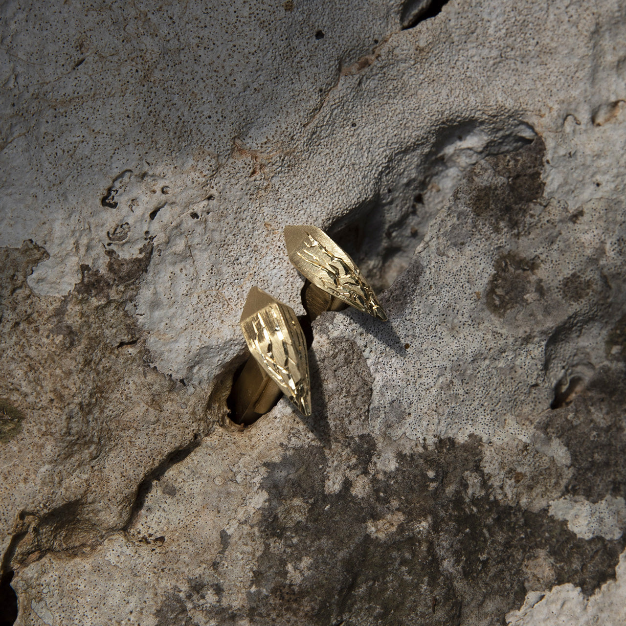 Luxury Infranti Distanti earrings handcrafted in 18K yellow ethical gold with tribal-inspired engraved details, evoking the raw beauty of nature in motion – designed by Riccardo Contini