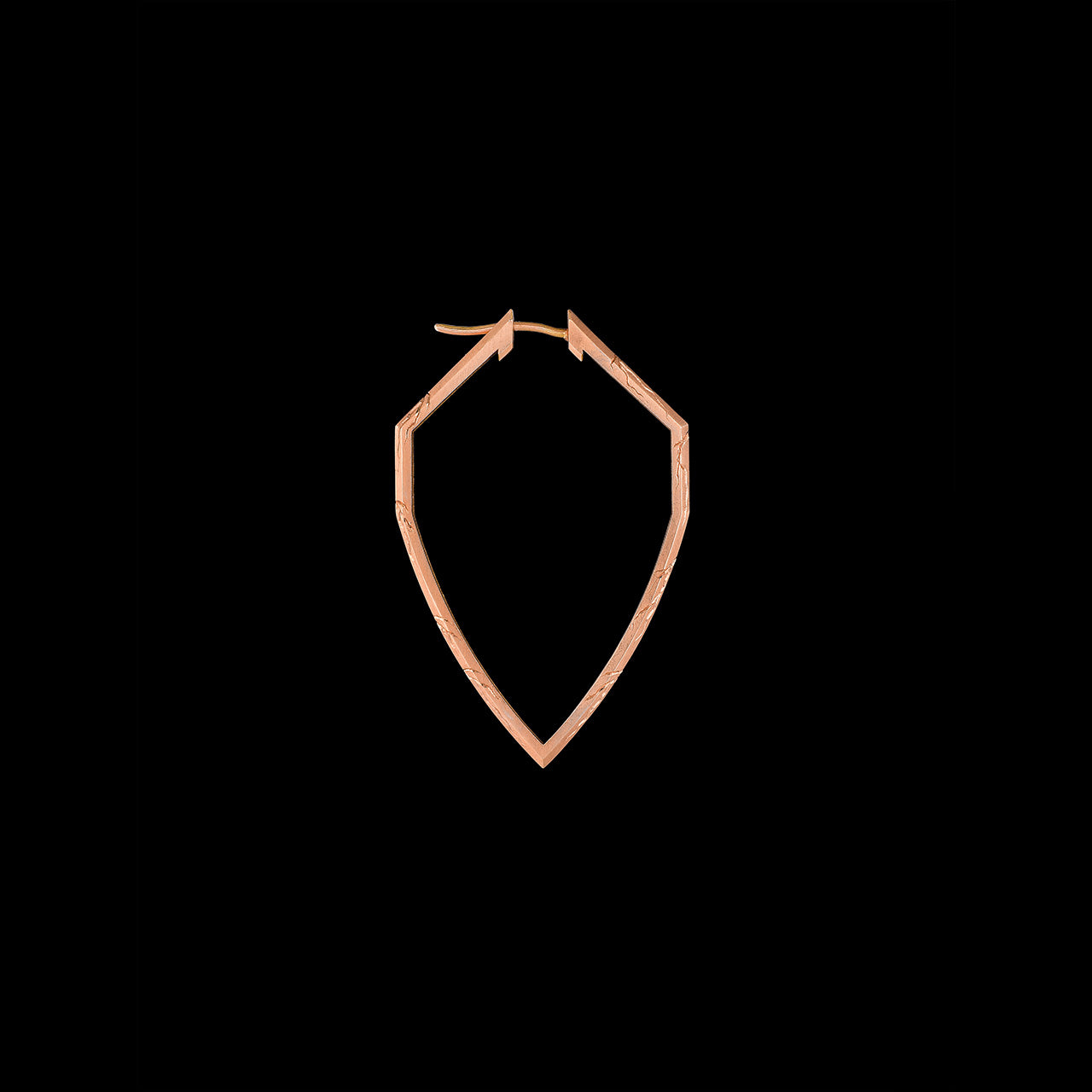 These engraved hoops in 18kt FairTrade rose gold echo the form of a shield—protective, poised, and precise.A minimal gesture of strength, drawn from the earth and worn with purpose.